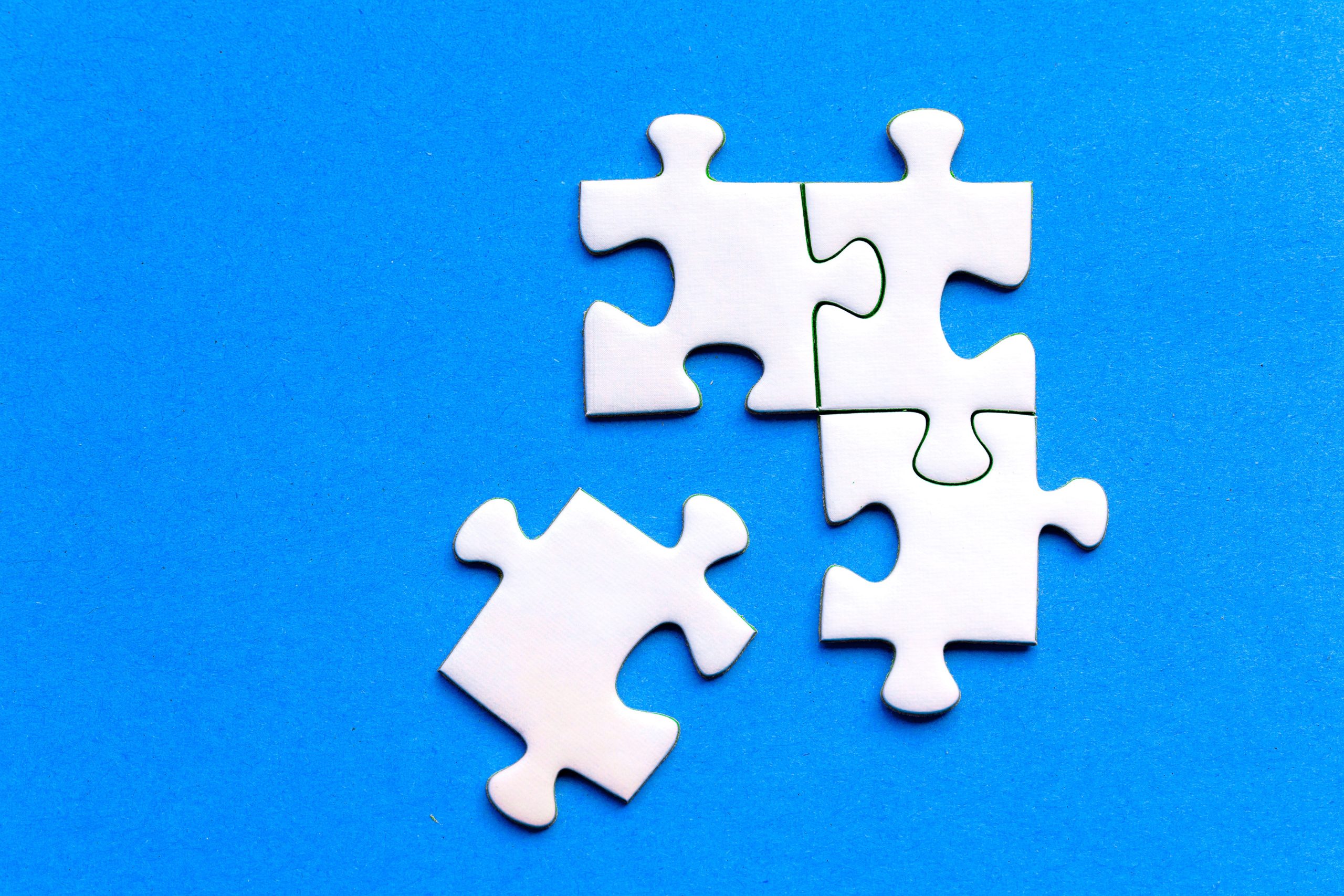 White puzzle pieces against a blue background.